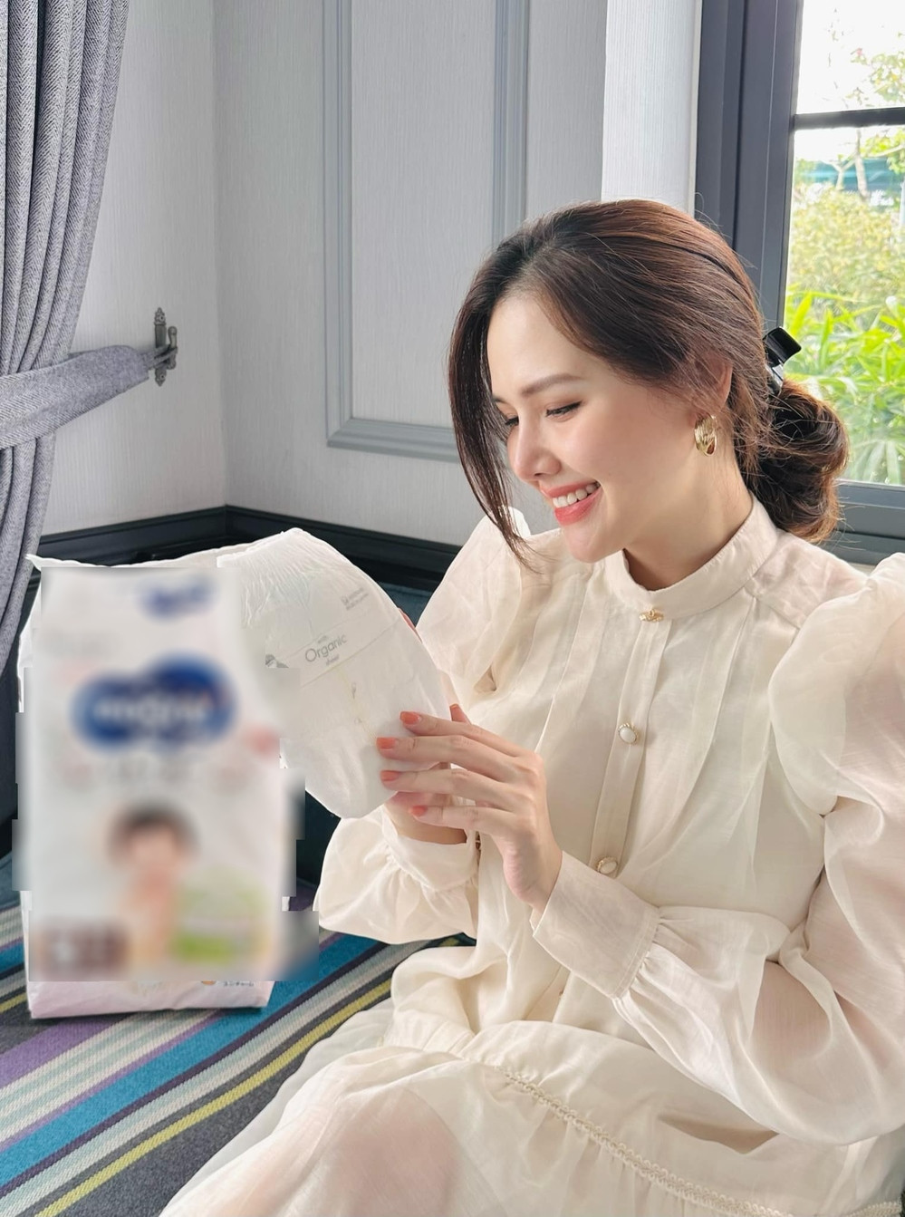 Trong khung ảnh, người đẹp gốc Hà thành diện thiết kế tông trắng dáng rộng để che chắn vòng 2 sau sinh.