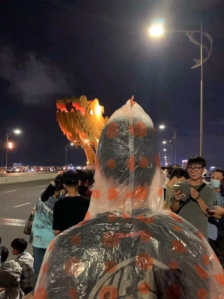 Nhiều người bật cười vì hành động của anh nhưng cũng tỏ ý đồng cảm, cho rằng chỉ những ai từng trải qua cảm giác đứng gần cầu Rồng xem phun nước mới thấu hiểu cho hành động của nhân vật trong bức ảnh. Ảnh: Tổng hợp