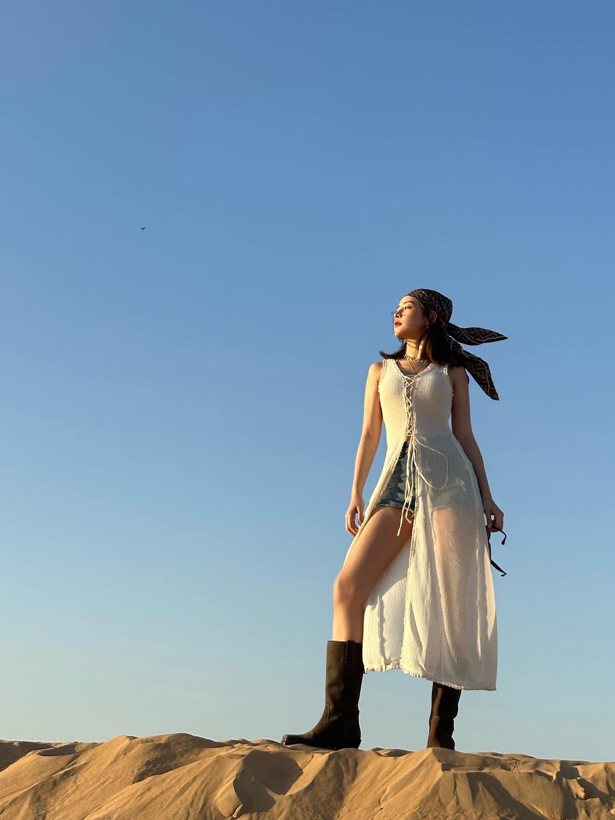 Diện áo xẻ tà dài thiết kết thắt dây hở vai kết hợp với quần short jeans giúp mỹ nhân Việt khoe triệt để đôi chân thon dài, nuột nà.