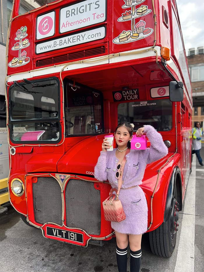 Ngân Anh chọn bộ váy áo lông màu tím, đi tất cao cổ màu đen khi du lịch Anh quốc.