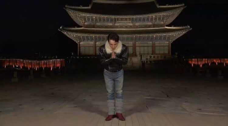 Giọng ca "Making My Way" kết hợp áo khoác da đen có cổ lót lông màu be cùng quần jeans và giày bốt mũi nhọn. Ảnh cắt clip Gucci Cruise 2024.