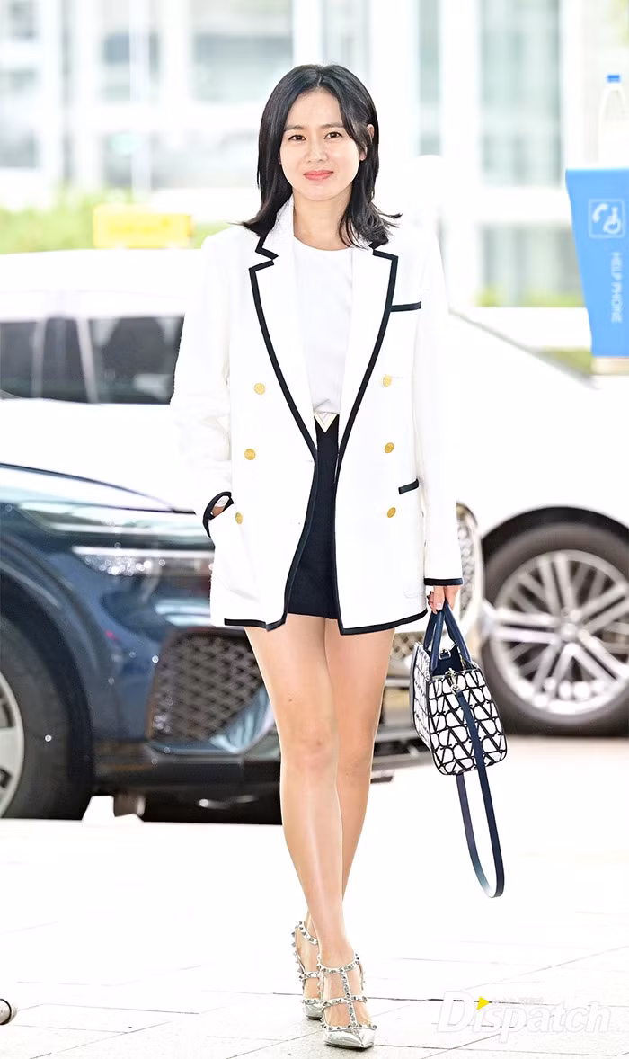 Bà mẹ một con rạng ngời, trẻ trung trong trang phục thanh lịch với áo vest trắng, quần short đen. (Ảnh: Dispatch)