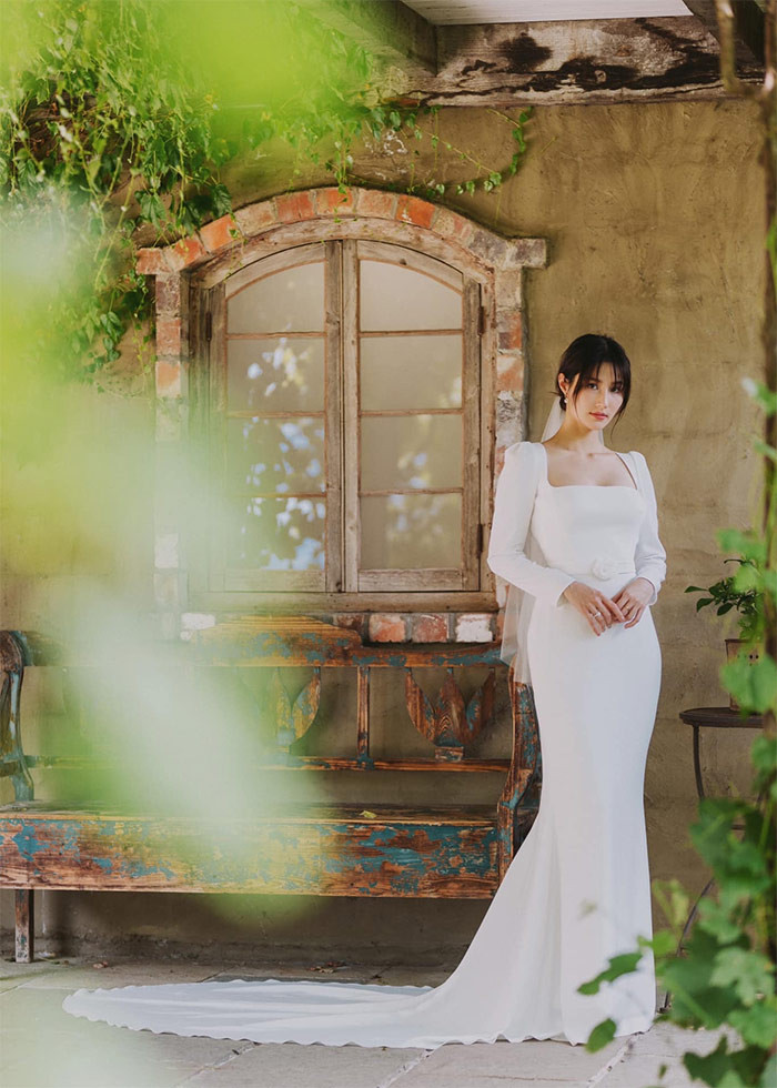 Diễm My trong một thiết kế váy cưới khác với phần đuôi cá dài hơn và phần thân áo ôm sát, cổ áo khoét sâu khoe vòng 1 lấp ló.