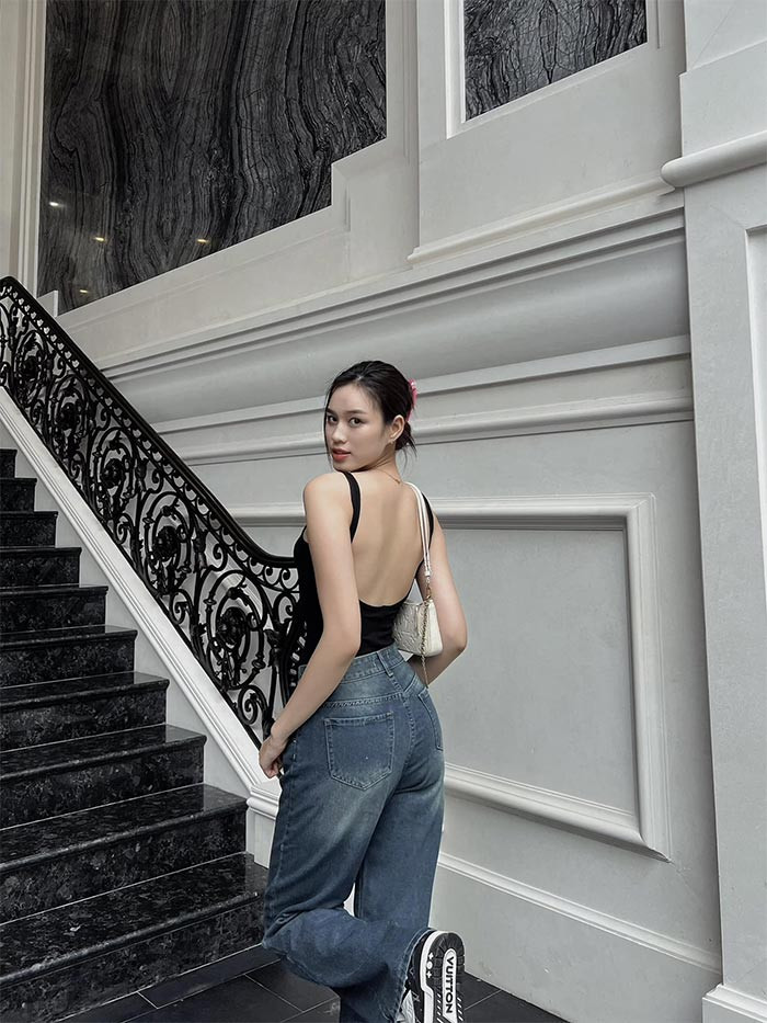 Hoa hậu Việt Nam 2020 trẻ trung, quyến rũ khi kết hợp quần jeans ống rộng với áo hở lưng và giầy thể thao.