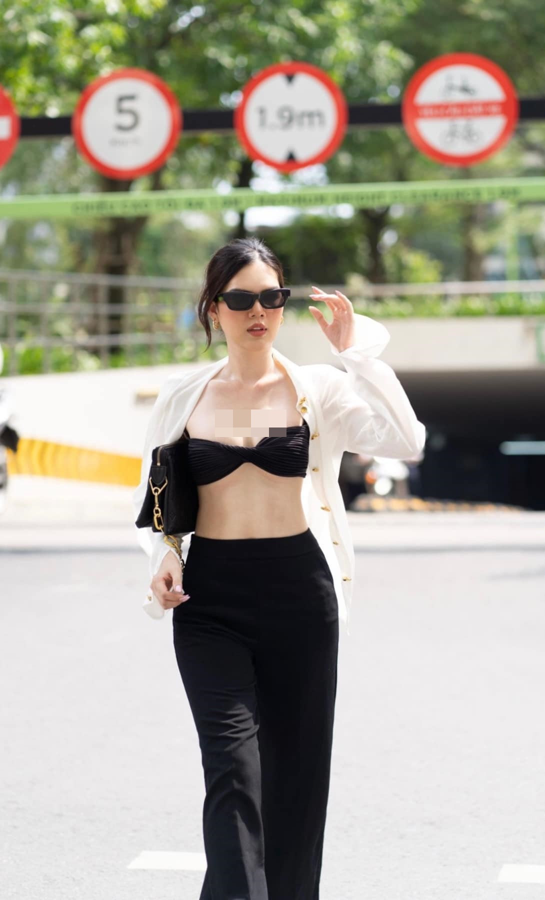 Mỹ nhân sinh năm 1996 diện đồ công sở nhưng lại phá cách bằng việc bung hết hàng cúc áo sơ mi trắng lộ nội y tối màu.