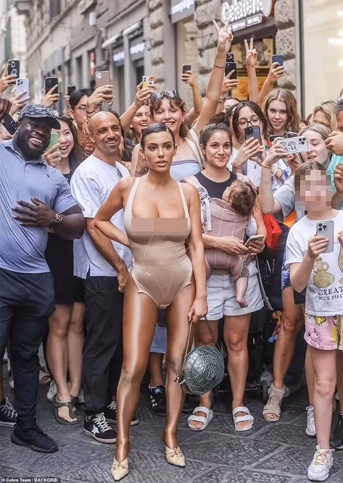 Nữ kiến trúc sư 28 tuổi người Australia mặc một bộ đồ như áo tắm, màu nude, chân đi tất da cùng giày cao gót. (Ảnh: Backgrid)