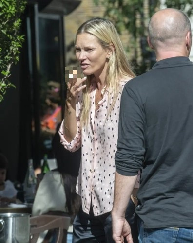 Siêu mẫu người Anh cùng bố và anh trai cùng nhau đi ăn tại nhà hàng. Cô giản dị trong trang phục áo sơ mi chấm bi đen hồng, quần dài màu đen, chân đi dép sandal. (Ảnh: Splash News)