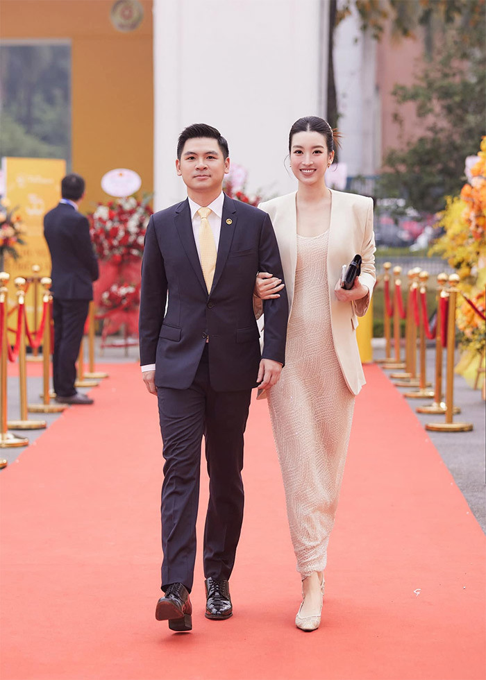Đỗ Mỹ Linh mặc bộ váy và khoác áo vest cùng tông màu pastel rất thanh lịch, tươi tắn khoác tay chồng trên thảm đỏ sự kiện.