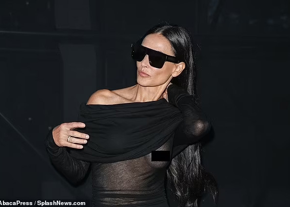 Diện trang phục xuyên thấu, khi giơ tay lên tạo dáng chụp ảnh, Demi Moore vô tình để lộ một bên ngực. (Ảnh: SplashNews)