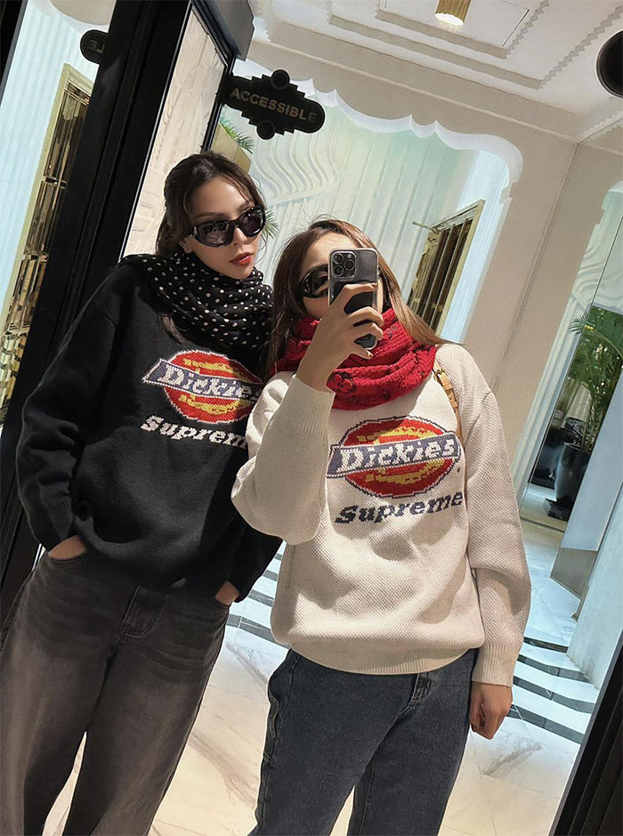 Hai người mặc áo nỉ đôi, một đen, một trắng kết hợp với quần jeans ống suông.