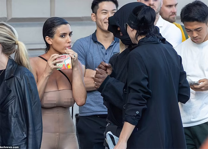 Phong cách thời trang kỳ quặc của hai vợ chồng Kanye West không khiến những người đứng xếp hàng cùng phải bận tâm, để ý. (Ảnh: Splasnews)