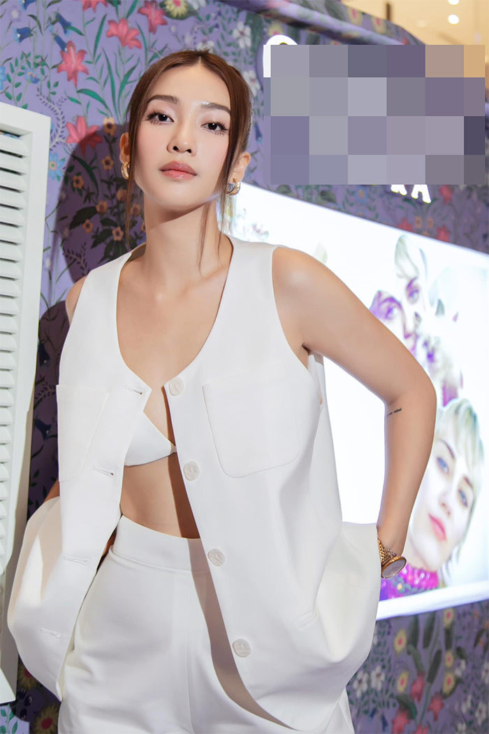 Nữ diễn viên sinh năm 1997 mặc một bộ vest gile màu trắng, để lộ bra cùng màu.