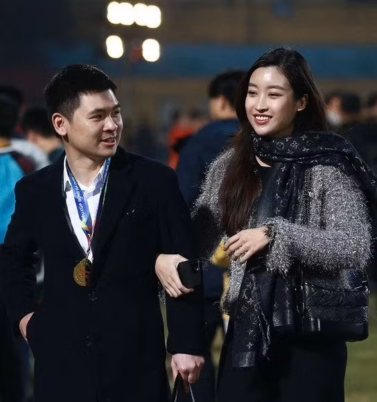 Sau khi kết hôn với chồng đại gia, trở thành dâu hào môn, Đỗ Mỹ Linh dùng đồ hiệu nhiều hơn. Trong một lần ra sân vận động cùng chồng, cô chọn một chiếc áo màu ghi và điểm nhấn là chiếc khăn quàng LV. (Ảnh: ngoisao.vn)