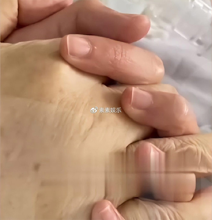 Hai vợ chồng nắm tay nhau rất tình cảm trong đám cưới.