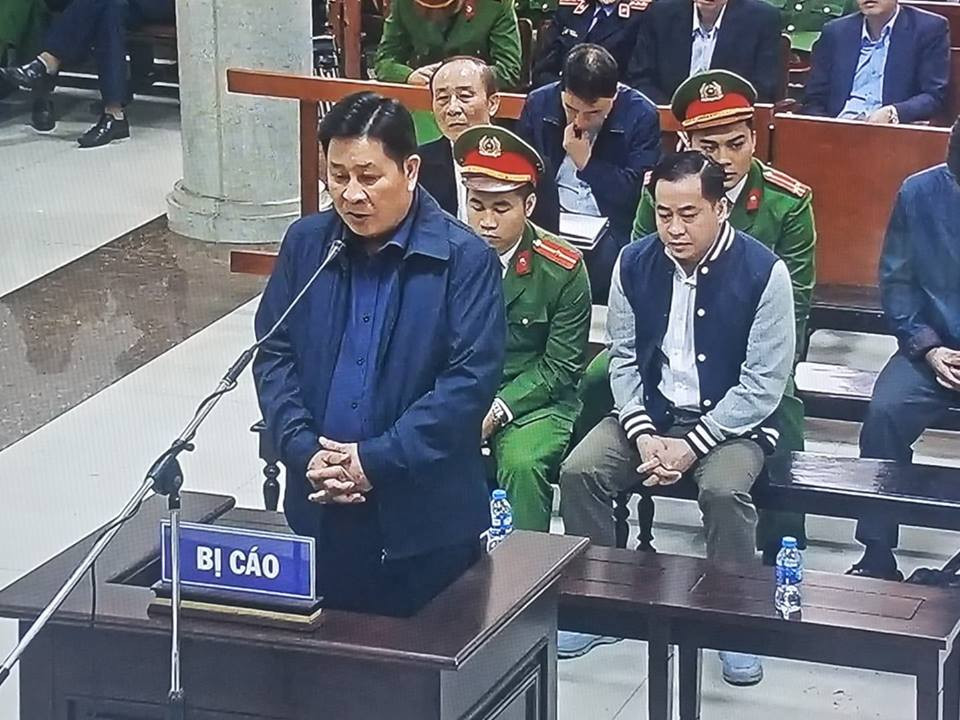 Bị cáo Bùi Văn Thành đứng lên trả lời căn cước. (Ảnh chụp qua màn hình).