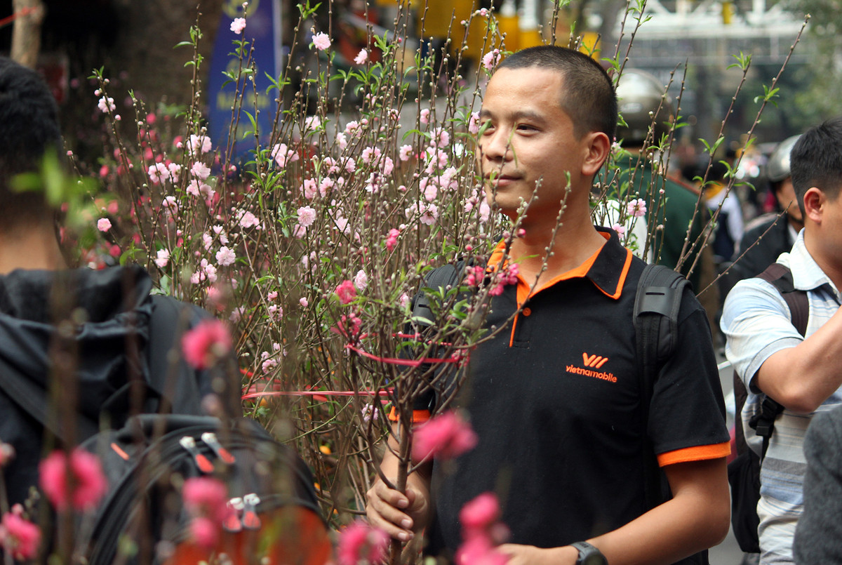 Những người đàn ông khá thích thú với những cành hoa đào được bán tại chợ hoa Hàng Lược.