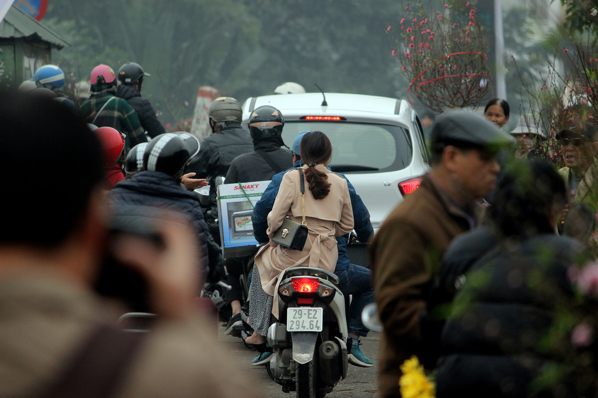 Do lượng người đổ xô đến khu vực chợ Quảng An rất đông khiến các đoạn đường xung quanh chợ luôn rơi vào cảnh ùn tắc, ô tô xe máy phải di chuyển ì ạch.
