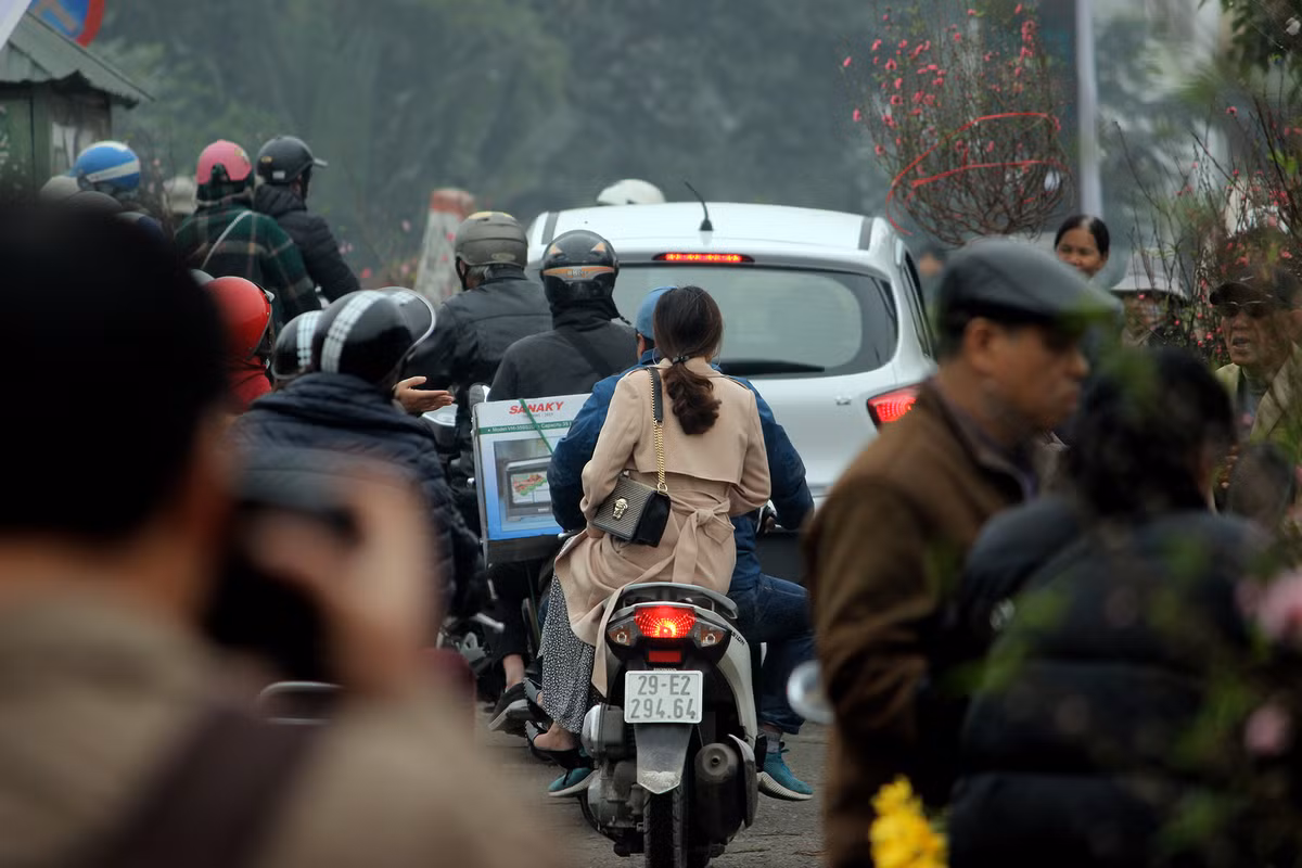 Do lượng người đổ xô đến khu vực chợ Quảng An rất đông khiến các đoạn đường xung quanh chợ luôn rơi vào cảnh ùn tắc, ô tô xe máy phải di chuyển ì ạch.