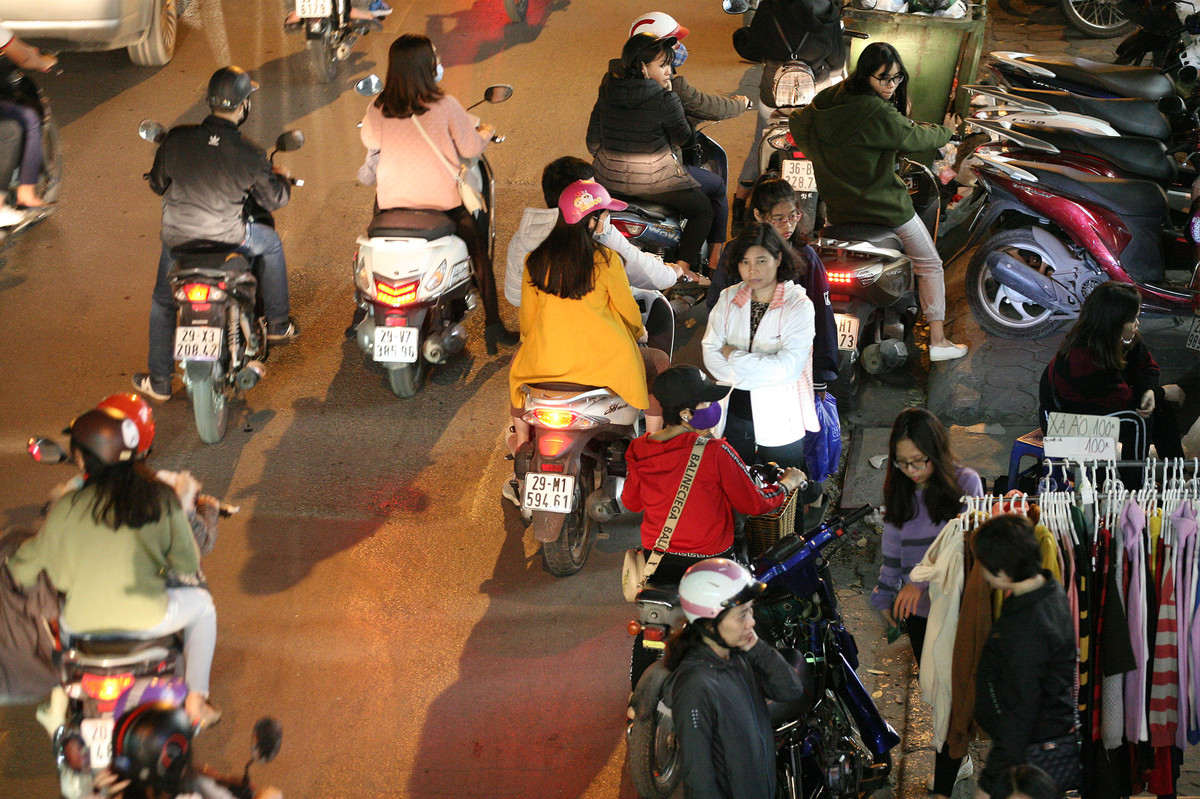 Quần áo được bày ra sát mép đường.