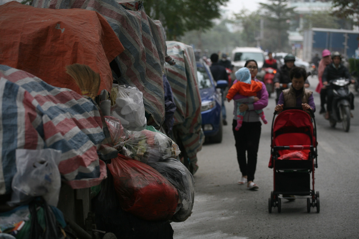 Những xe rác chất đầy rác thải sinh hoạt tạm thời được công nhân môi trường phủ bạt để tránh bốc mùi hôi thối, nhưng cũng không ngăn nổi mùi hôi thối.