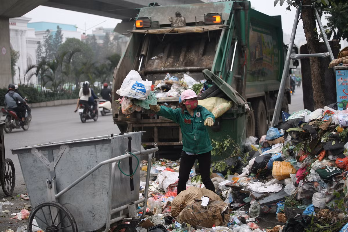Theo nữ công nhân này, họ tạm thời thu gom rác lên xe chứ chưa biết chở đi đâu do đường vào khu liên hợp xử lý chất thải Sóc Sơn sáng nay vẫn bị dân chặn.