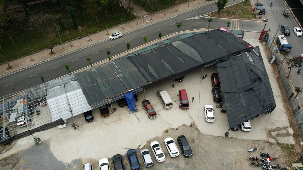 Hiện trạng trong khuôn viên bãi có gần trăm chiếc xe ô tô. Khu đất này đã quây tôn cao xung quanh và có một dãy nhà lợp tôn, căng lưới đen trên mái.