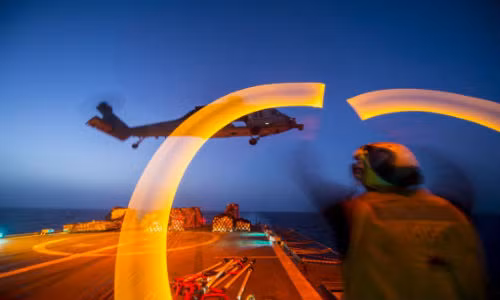 Một nhân viên kiểm soát không lưu đang hướng dẫn cho trực thăng MH-60S Sea Hawk hạ cánh trên boong tuần dương hạm USS Philippine Sea (lớp Ticonderoga). Nhiệm vụ của Sea Hawk là tiếp tế hàng hóa, trinh sát, chống ngầm, tìm kiếm cứu nạn, hay chuyên chở lực lượng đặc nhiệm. Đây là một khoảnh khắc hoạt động về đêm ấn tượng của Hải quân Mỹ.