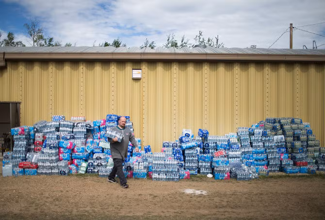Cư dân Rodney Howse lấy nước tại một trung tâm cứu hộ được thành lập để giúp những người dân phải sơ tán do cháy rừng Fort McMurray ở Winding River ngày 8/5.