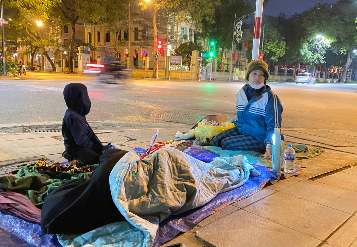 Những người vô gia cư nằm ngủ trên vỉa hè dưới thời tiết lạnh tê tái, gió thổi mạnh từng cơn.