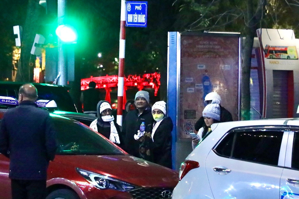 Nhóm du khách nước ngoài trang bị cả mũ len, khăn quàng cổ, khẩu trang để "chống" lại cái rét trong mùa đông tại Việt Nam.