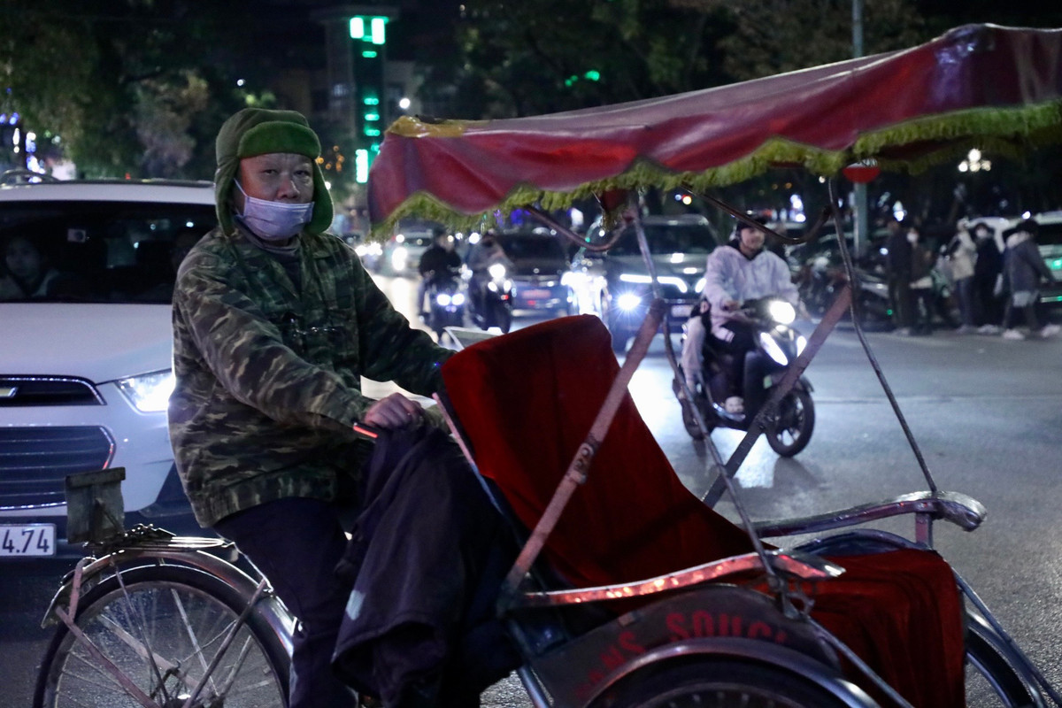 Bác đạp xe xích lô đội chiếc mũ trùm đầu, kín tai để giữ ấm trong thời tiết rét đậm.