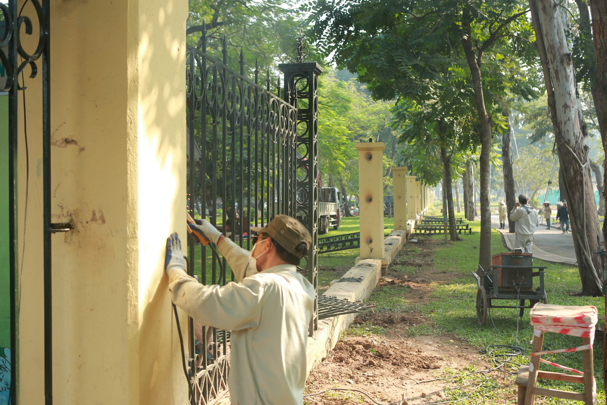 Khoảng 50 công nhân được chia làm 3 tổ, từ sáng đã tiến hành tháo dỡ phần trụ sắt trên các cột trụ của hàng rào công viên Thống Nhất.