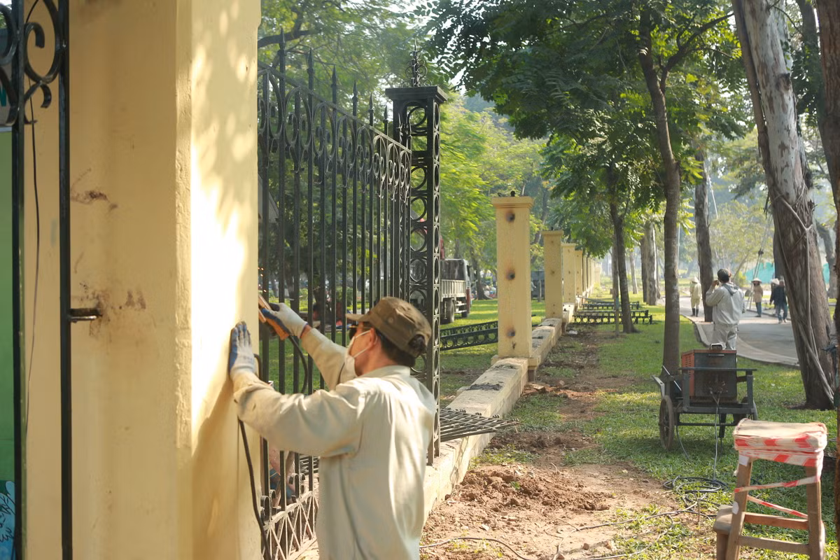 Khoảng 50 công nhân được chia làm 3 tổ, từ sáng đã tiến hành tháo dỡ phần trụ sắt trên các cột trụ của hàng rào công viên Thống Nhất.