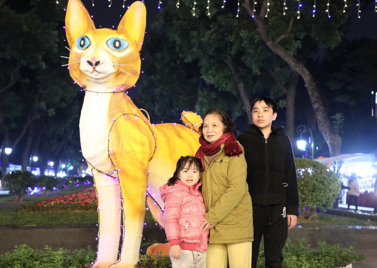 Người dân thích thú chụp ảnh bên linh vật Mèo (Xuân Quý Mão 2023) được xây dựng trong Công Viên Thống Nhất.