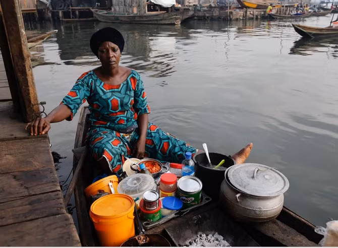 Người phụ nữ nấu ăn ngay trên thuyền giữa đầm phá Lagos.