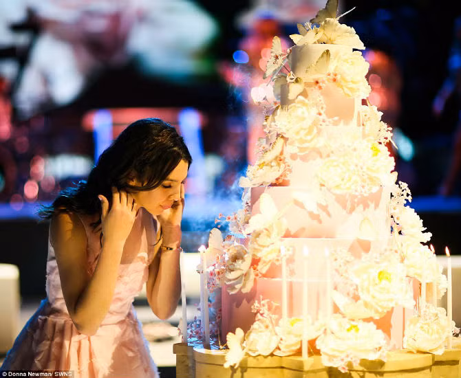 Maya Henry đang thổi nến trên chiếc bánh sinh nhật khổng lồ trong khi ca sĩ Pitbull và Nick Jonas biểu diễn trong bữa tiệc của cô.