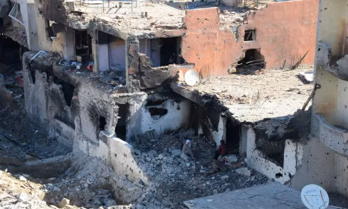 Người dân ngồi giữa đống đổ nát ở thị trấn Cizre.