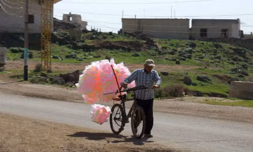 Người đàn ông Syria rong ruổi trên con đường ở thị trấn al-Ghariyah al-Gharbiyah, tỉnh Daraa để bán kẹo bông ngày 29/2.