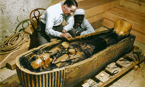 Nhà khảo cổ học Howard Carter và một công nhân Ai Cập kiểm tra quan tài thứ 3 làm bằng vàng được đặt trong 2 chiếc quan tài lớn ở bên ngoài năm 1925.