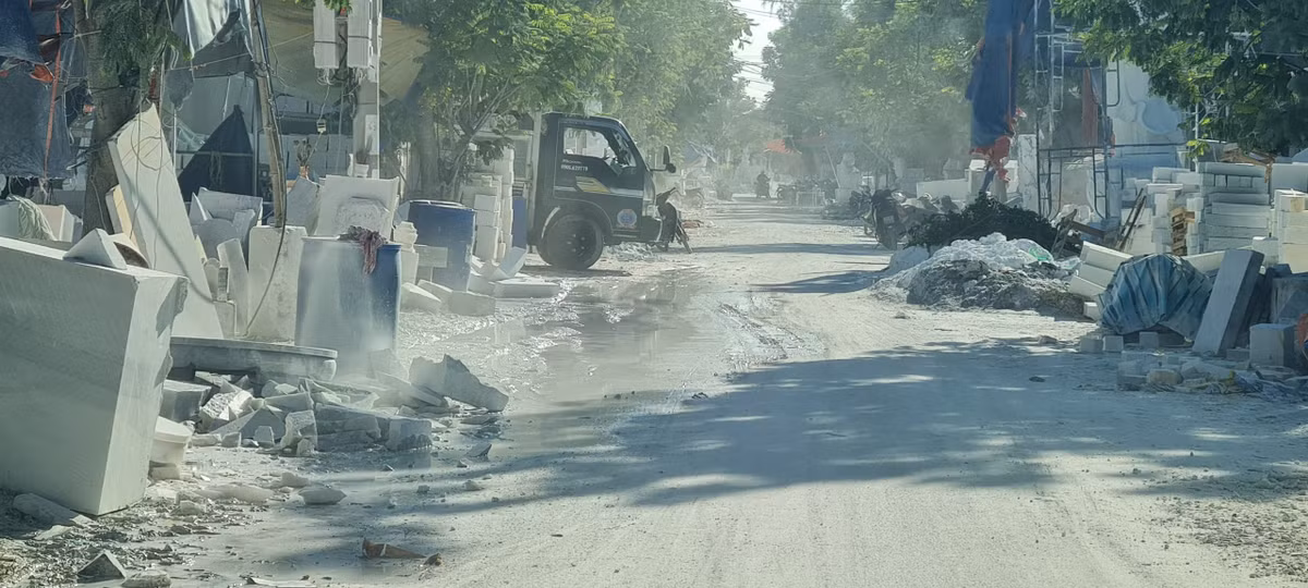 Trời nắng, con đường dẫn vào làng nghề nổi tiếng mù mịt bụi. Hai bên đường, la liệt các khối đá đủ thể loại, kích cỡ xen lẫn với những đống đá thải, bột đá.