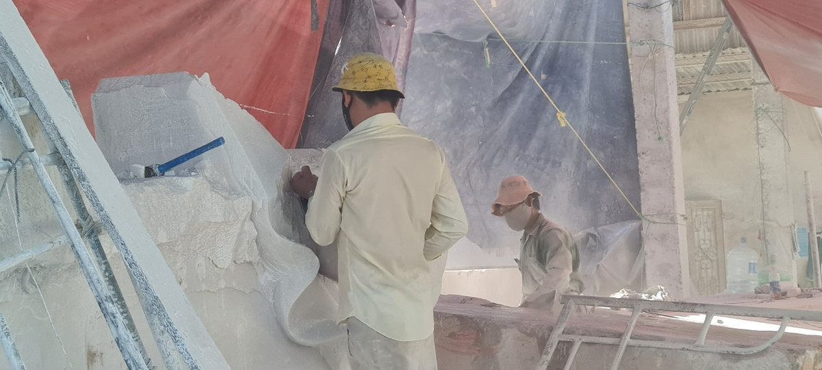 Dù được che tạm bằng bạt, bụi đá vẫn bay mù mịt từ các xưởng sản xuất ra khu vực xung quanh.