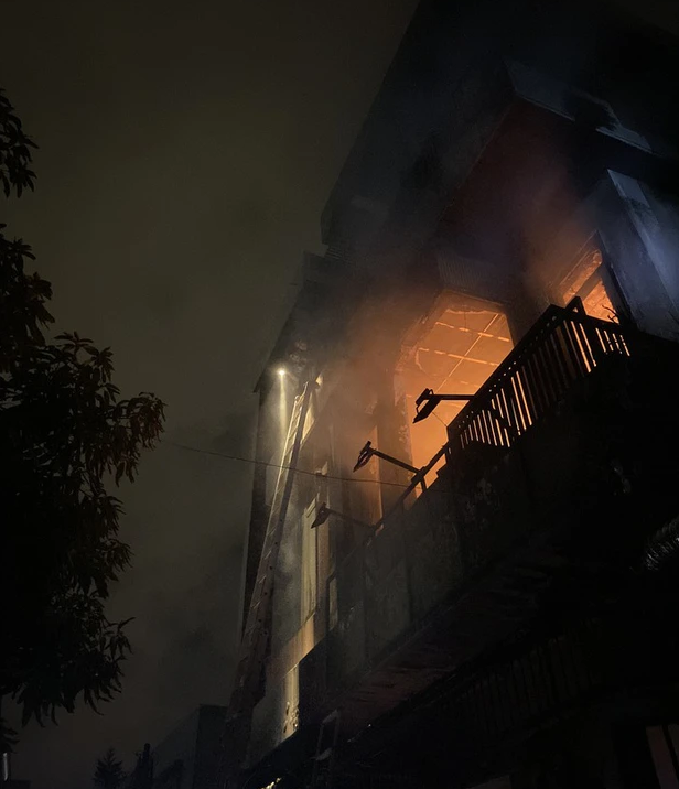 Những người sống ở sát vách ngôi nhà đang cháy gọi nhau tháo chạy vì sợ lửa cháy lan sang nhà mình.