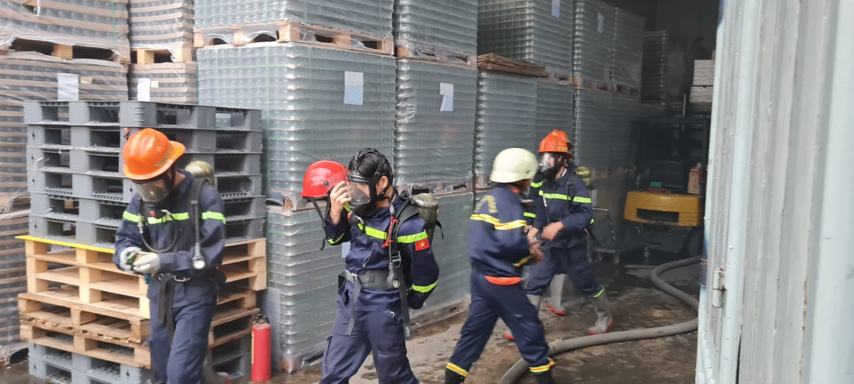 Cảnh sát phòng cháy chữa cháy sử dụng mặt nạ tiến vào bên trong cơ sở sản xuất.