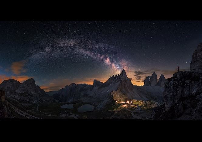 Bức ảnh toàn cảnh này được ghép từ 8 tấm ảnh khác nhau. Trong hình, chúng ta thấy dải Ngân Hà đang nằm ở phía trên dãy núi đá Dolomites Tre Cime. Bên phải hình là ánh sáng phát từ một ngôi nhà soi rõ cả dãy núi xung quanh.