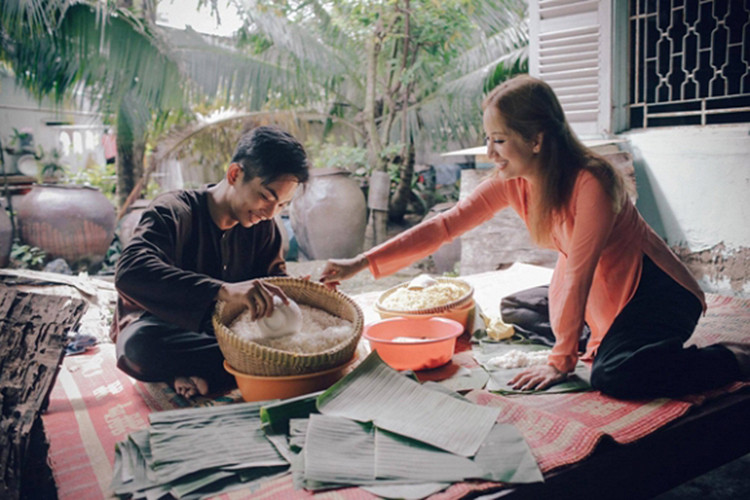 Cặp đôi mặc áo bà ba, tất bật gói bánh chưng chuẩn bị cho ngày Tết Nguyên Đán. Ảnh: VTV