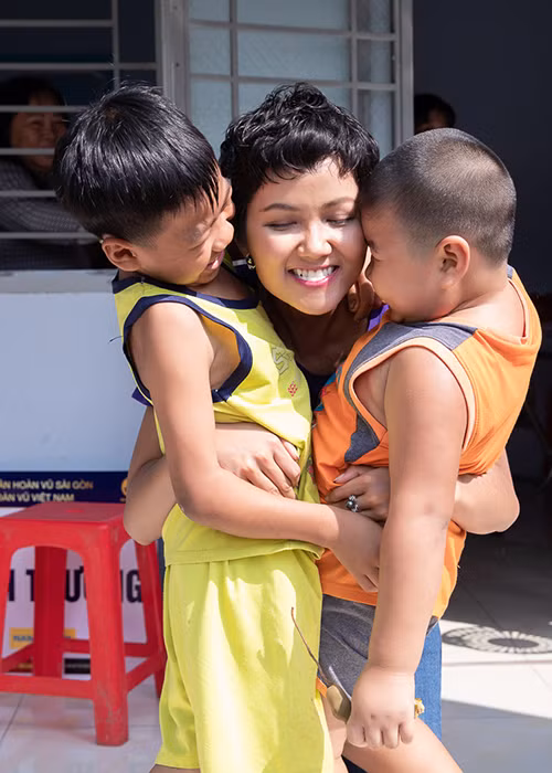 H'hen Niê vui vẻ chơi đùa cùng các em nhỏ trong khi đi trao quà Tết.