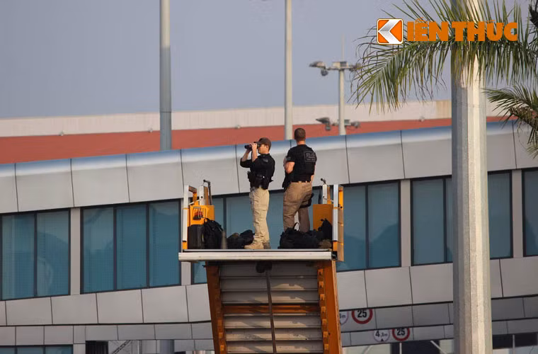 Hàng rào an ninh được bố trí dày đặc, quanh khu vực đón Tổng thống Trump tại Nội Bài. Trong ảnh, hai mật vụ Mỹ quan sát các khu vực xung quanh bằng cách sử dụng xe thang.