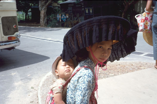 Hình ảnh ấm áp một người mẹ địu con trên lưng.