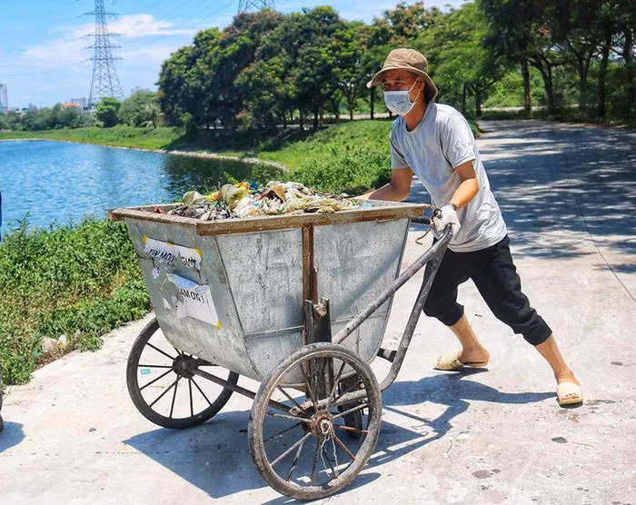 Công nhân môi trường tập trung thu gom xác cá mang đi xử lý