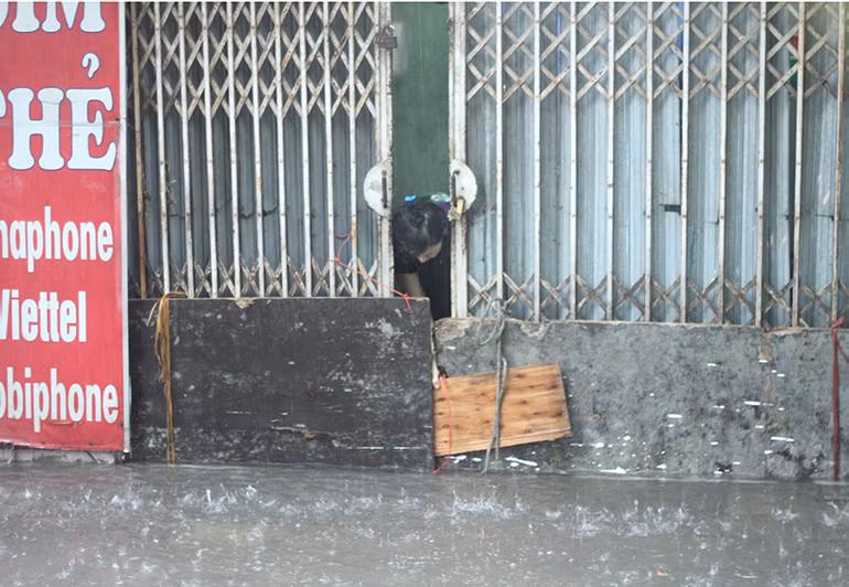 Những miếng ván được người dân che chắn, buộc chặt để nước không chảy tràn vào nhà trên phố Kim Mã Thượng.